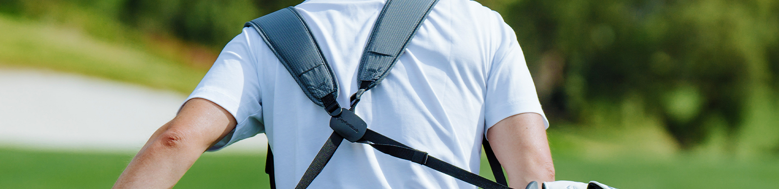 golfer carrying a golf bag showing off the golf bag's strap system